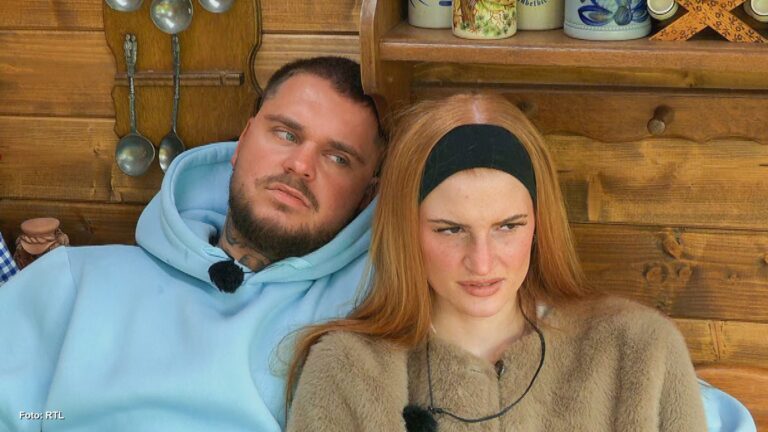 Laura Parrinello und Nico Legat auf dem Sofa im Sommerhaus, Laura mit skeptischem Seitenblick