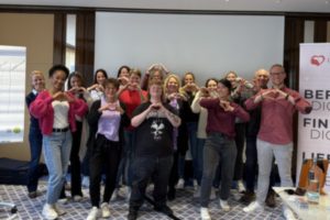 Gruppe formt Herzen mit den Händen beim Workshop in Stuttgart